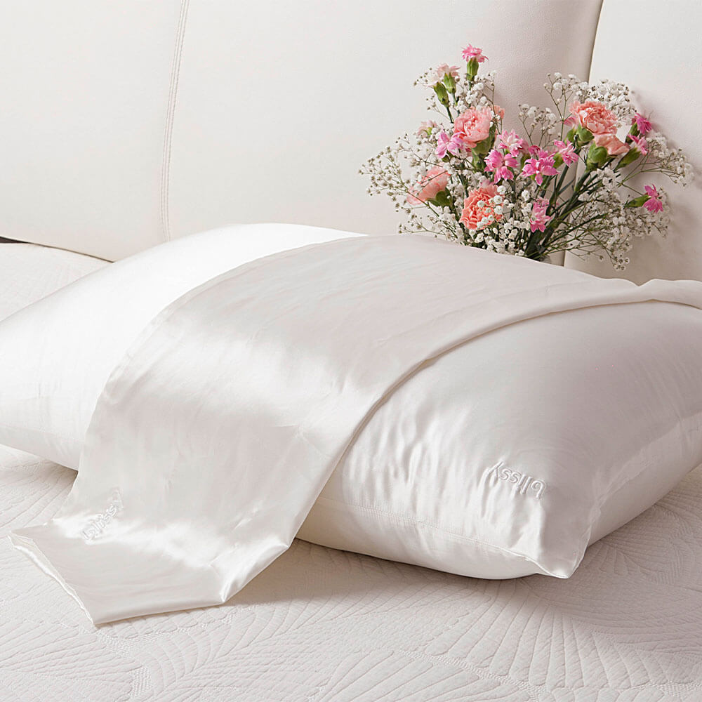 Pillow with Blissy mulberry silk white pillowcase on a couch with pink flowers