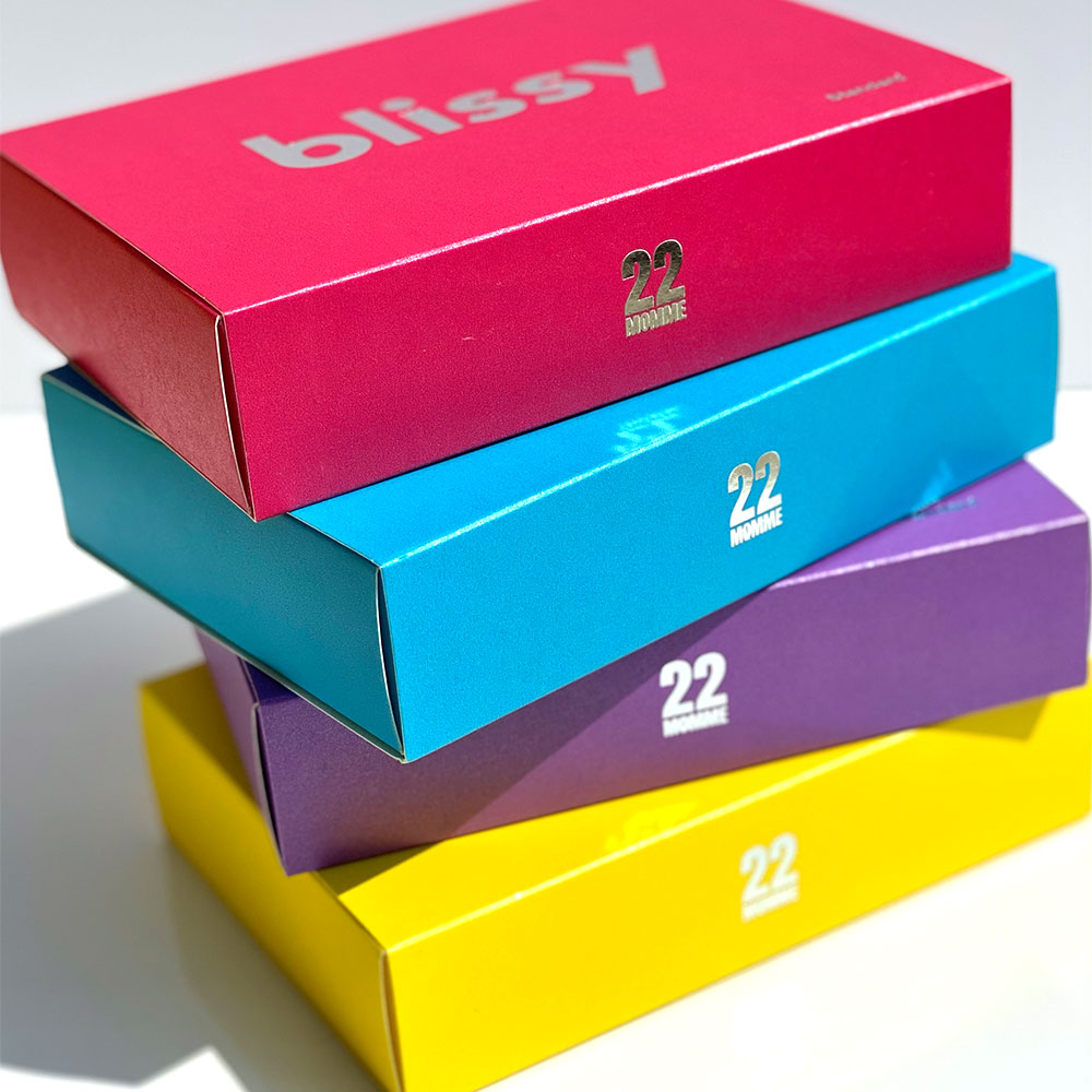 Stacked boxes of Blissy brights collection including hibiscus, bahama blue, orchid, and sunshine yellow