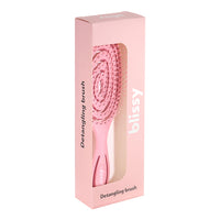 Pink detangling brush in a pink box on a white background