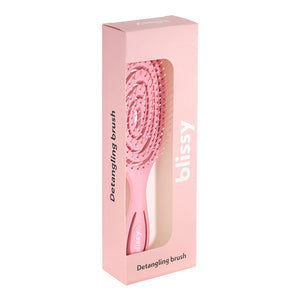 Pink detangling brush in a pink box on a white background